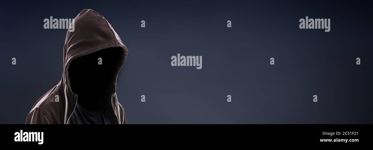 Invisible man wearing a hoodie on dark panoramic background with copy space Stock Photo