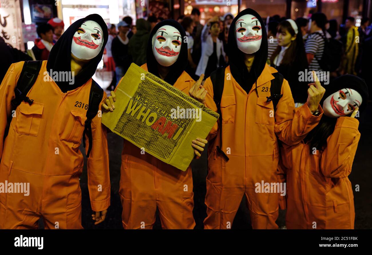 Four revelers in prisoner clown costumes pose together on a street in Shibuya, Tokyo, in celebration of Halloween Stock Photo