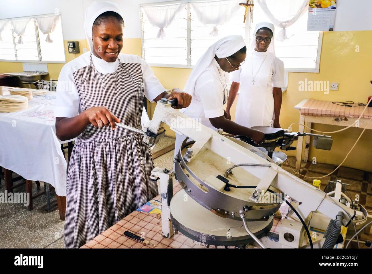 Young candidates of the Order of the 'Handmaids of the Divine Redeemer' (HDR) bake sacred hosts in the Catholic Novitiate Koforidoa, Ghana, Africa Stock Photo