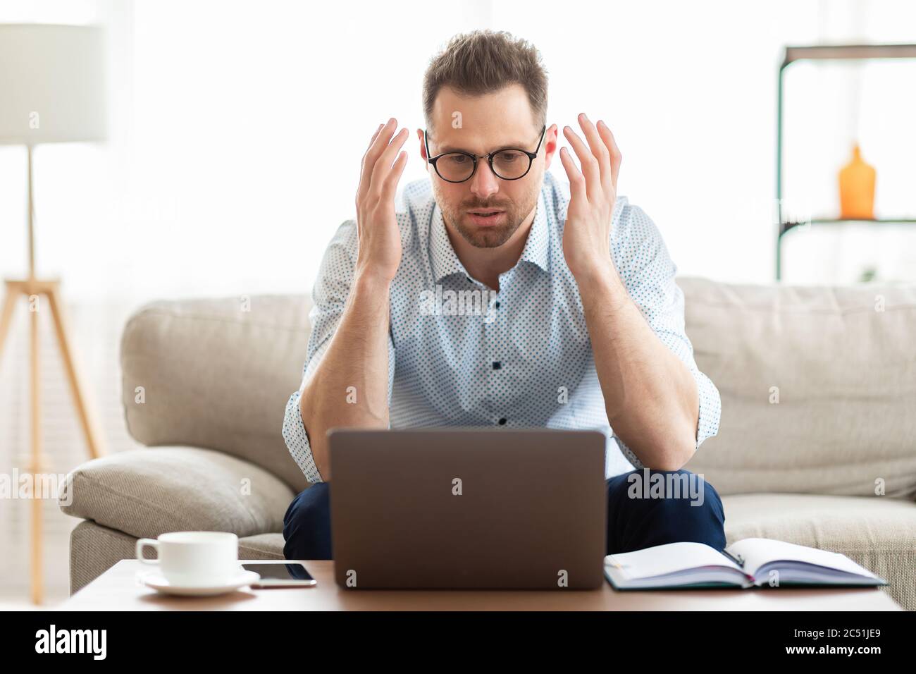 Shocked american manager using his pc at home Stock Photo