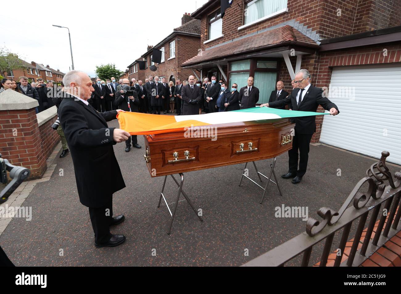 Sean Murray (left) and Gerry Kelly (right) place an Irish flag onto the coffin of senior Irish Republican and former leading IRA figure Bobby Storey ahead of his funeral in west Belfast. Stock Photo