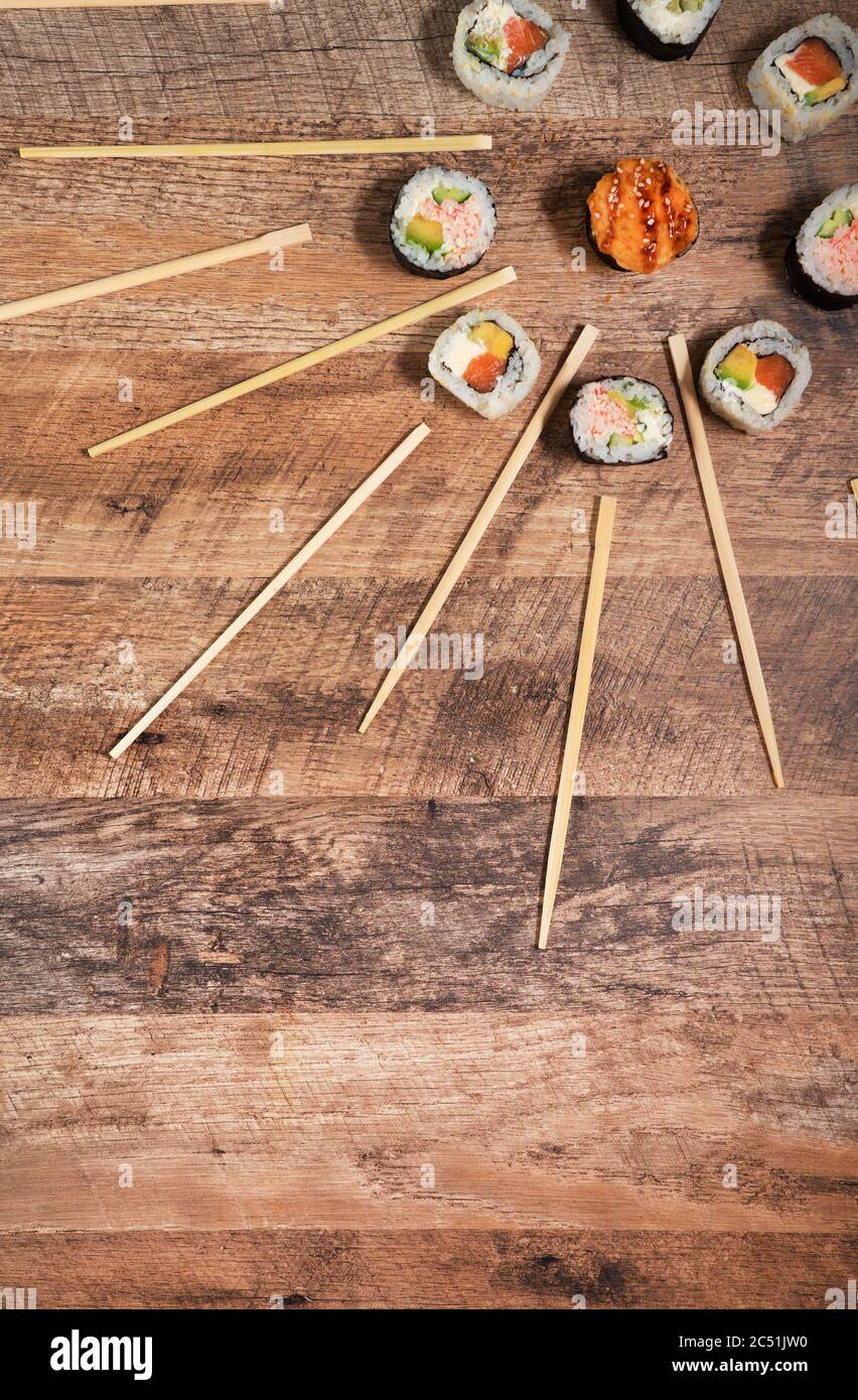 chopsticks and sushi roll on bamboo mat. background menu Stock Photo - Alamy