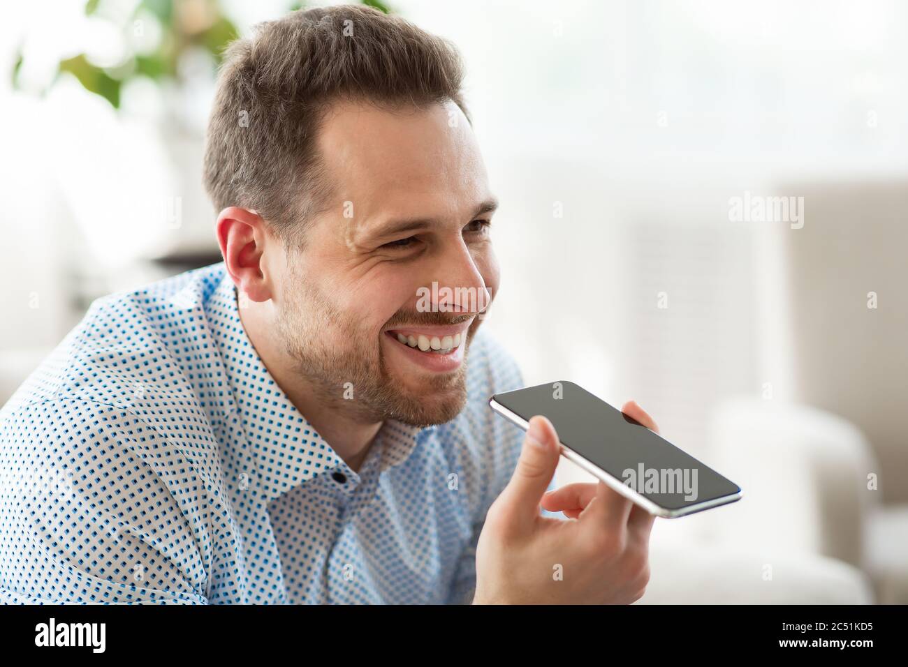 Adult man using voice assistant on smartphone Stock Photo