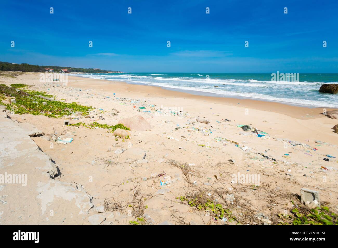 Sad picture with lots of rubbish in natural place. Summer seascape with Ke Ga Lighthouse in Vietnam. Landscape taken from the beach with blue sky on t Stock Photo