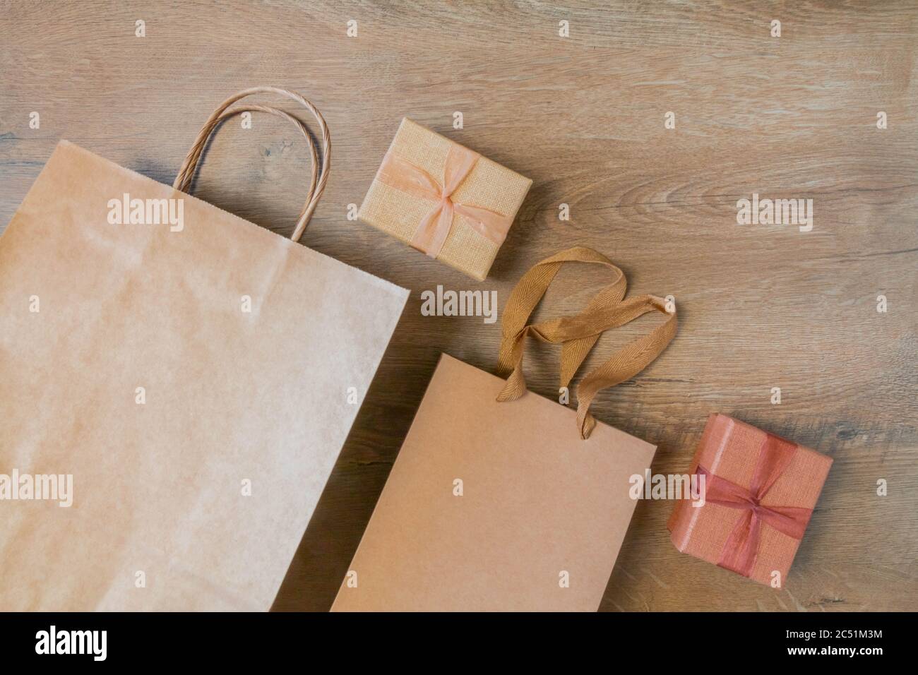 Craft paper bags and cardboard blank boxes presented on rustic wooden background. Unlabeled cardboard packages boxes and bags on wood table. Top view Stock Photo