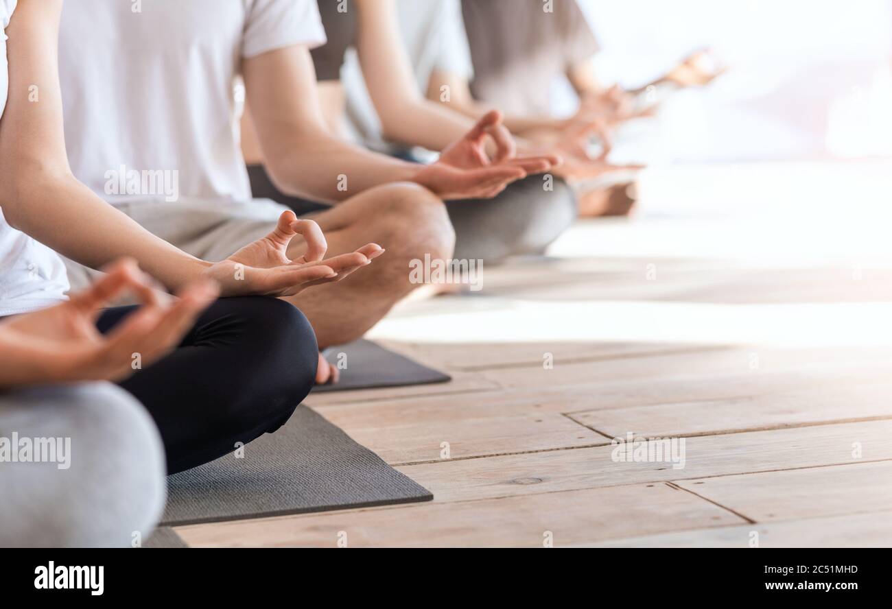 Zen And Meditation. Group Of People Meditating Together In Lotus Position, Cropped Stock Photo