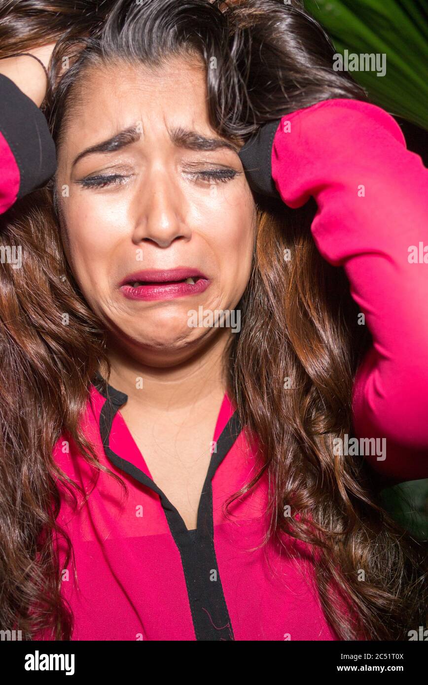Face of stressed young Indian businesswoman looking sad and crying Stock Photo
