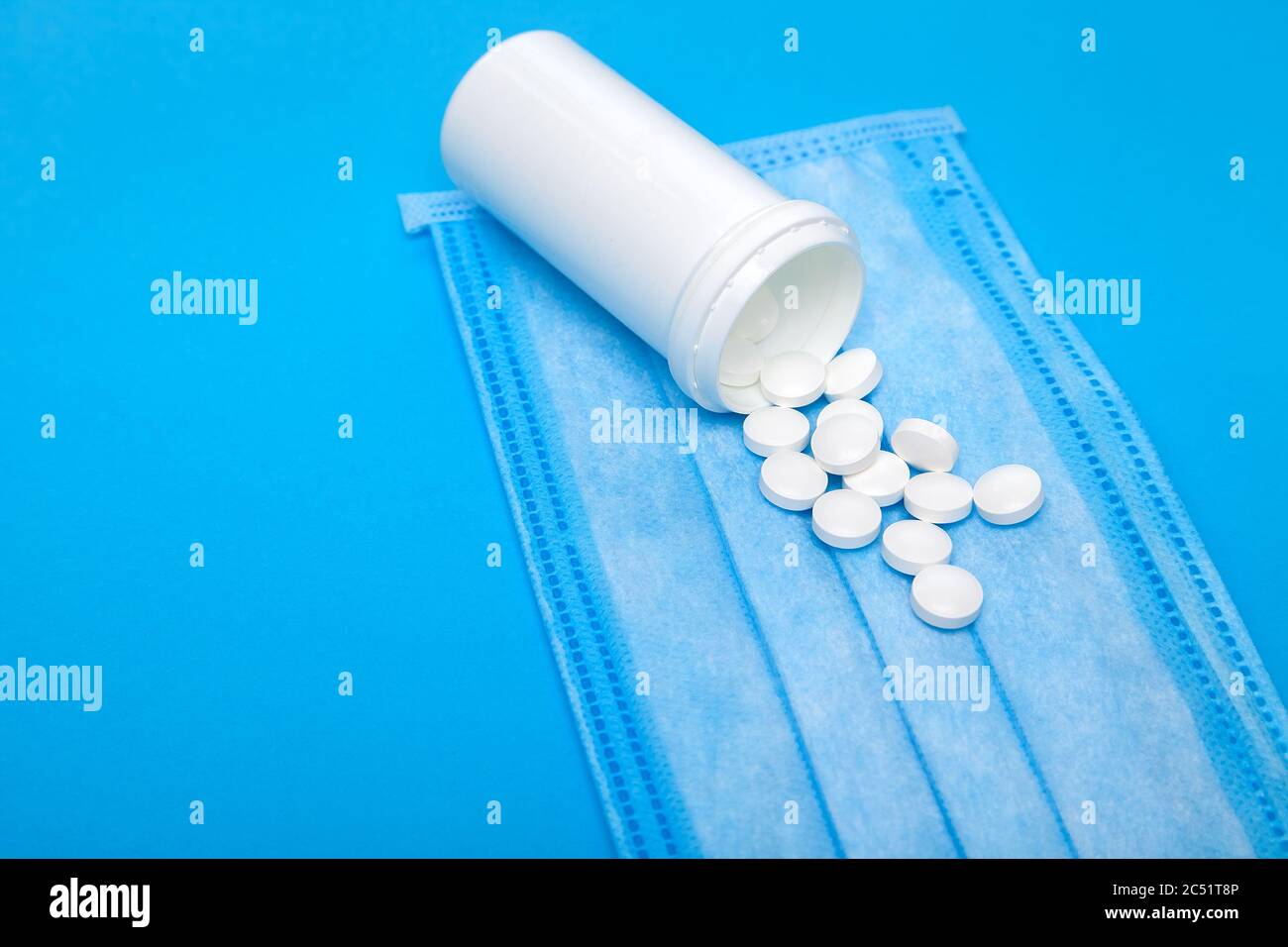 Mock Up Medical Mask With A Bottle Of A Medicinal Product With A Scattered Pile Of Pills On A Blue Background With Copy Space Stock Photo Alamy