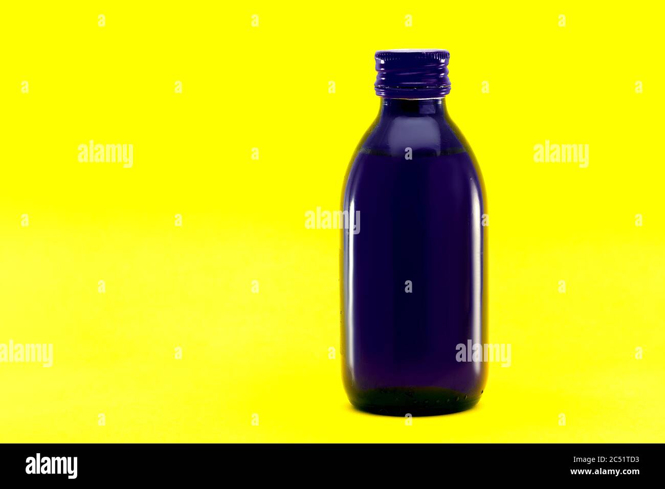cough syrup medical blue glass bottle isolated on yellow background