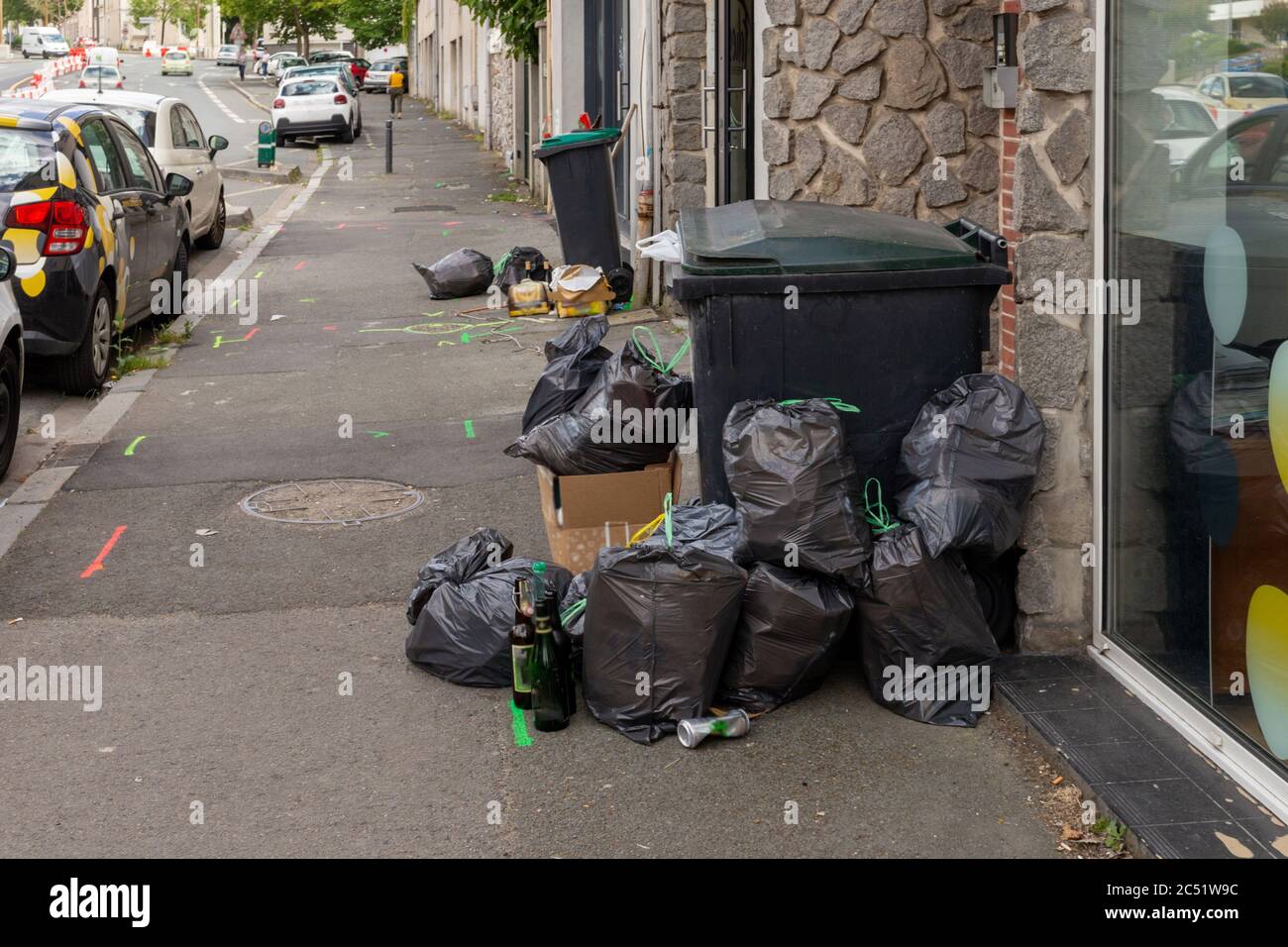 overloaded trash bin on the street, black plastic bag, trash waste ...