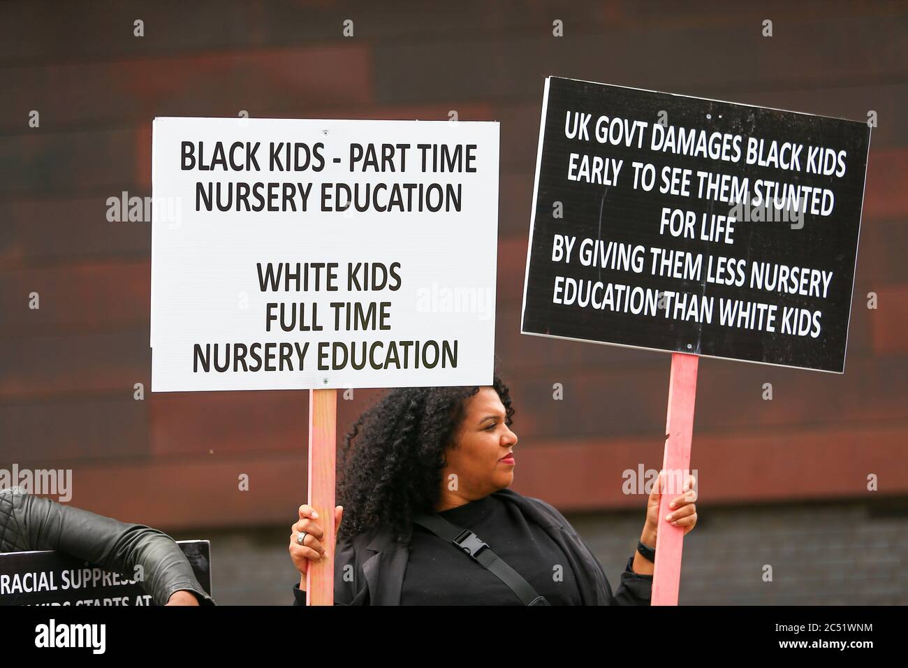 Dudley, West Midlands, UK. 30th June, 2020. As the Prime Minister Boris Johnson gave a speech in Dudley, a handful of protesters outside the college he was speaking in held up placards demanding full time nursery places for black children. Credit: Peter Lopeman/Alamy Live News Stock Photo