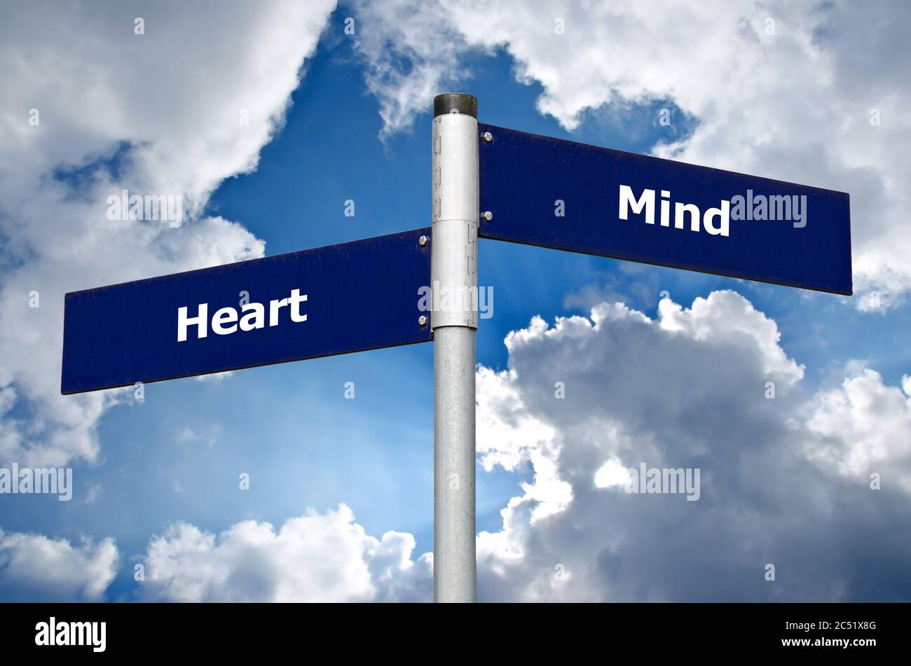 Street sign in front of cloudy sky representing choice between listening to the ‘heart’ or the ‘mind’ Stock Photo