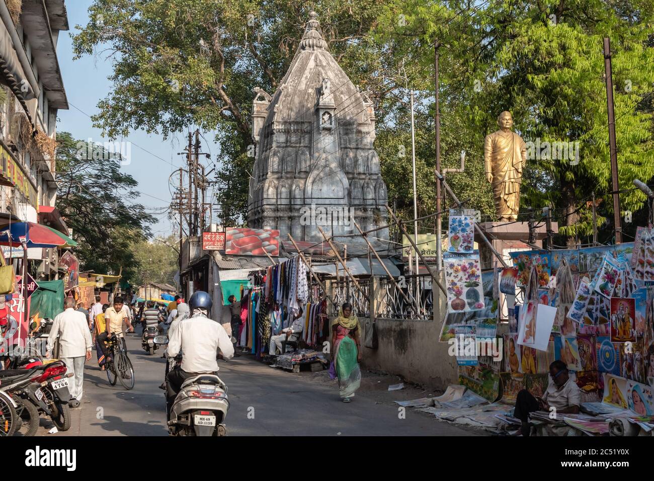 Nagpur, Maharashtra, India - March 2019: Traffic on the streets outside an old Hindu temple on the market streets of the Mahal area of the old city. Stock Photo