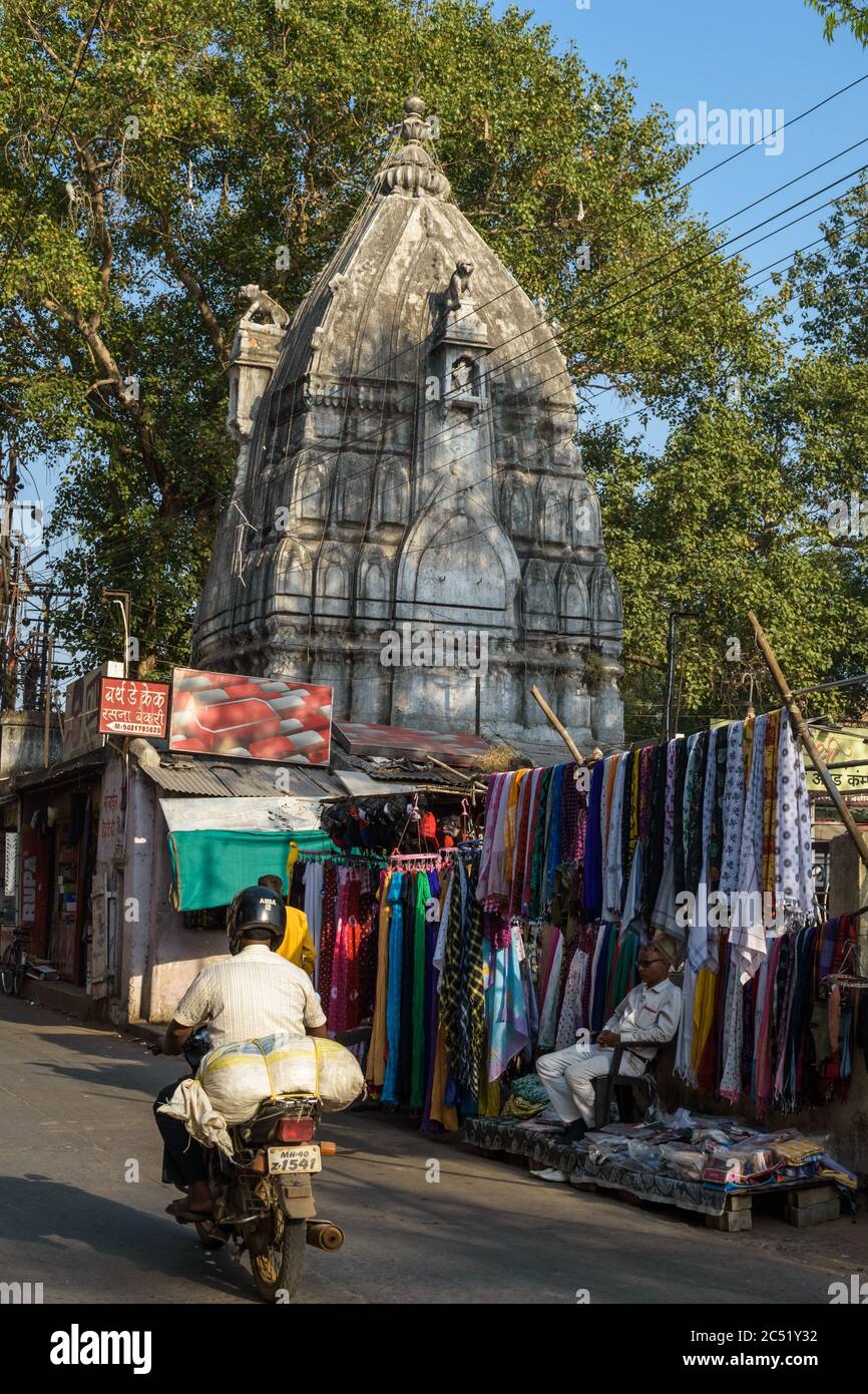 Nagpur, Maharashtra/India - March 8 2019: A market scene around an ancient Hindu temple in the Mahal area of old Nagpur. A garment store and a man on Stock Photo
