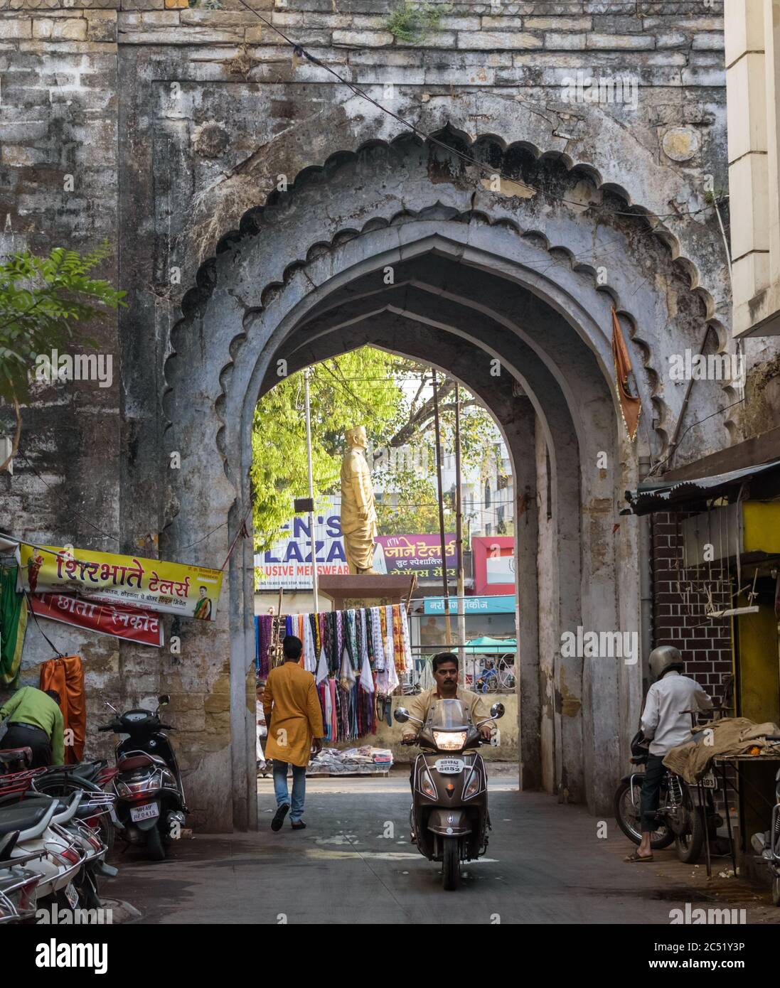 Nagpur, Maharashtra/India - March 8 2019: A man on a scooter rides through the arches  of an old gateway on the Pataleshwar Road in the Mahal area of Stock Photo