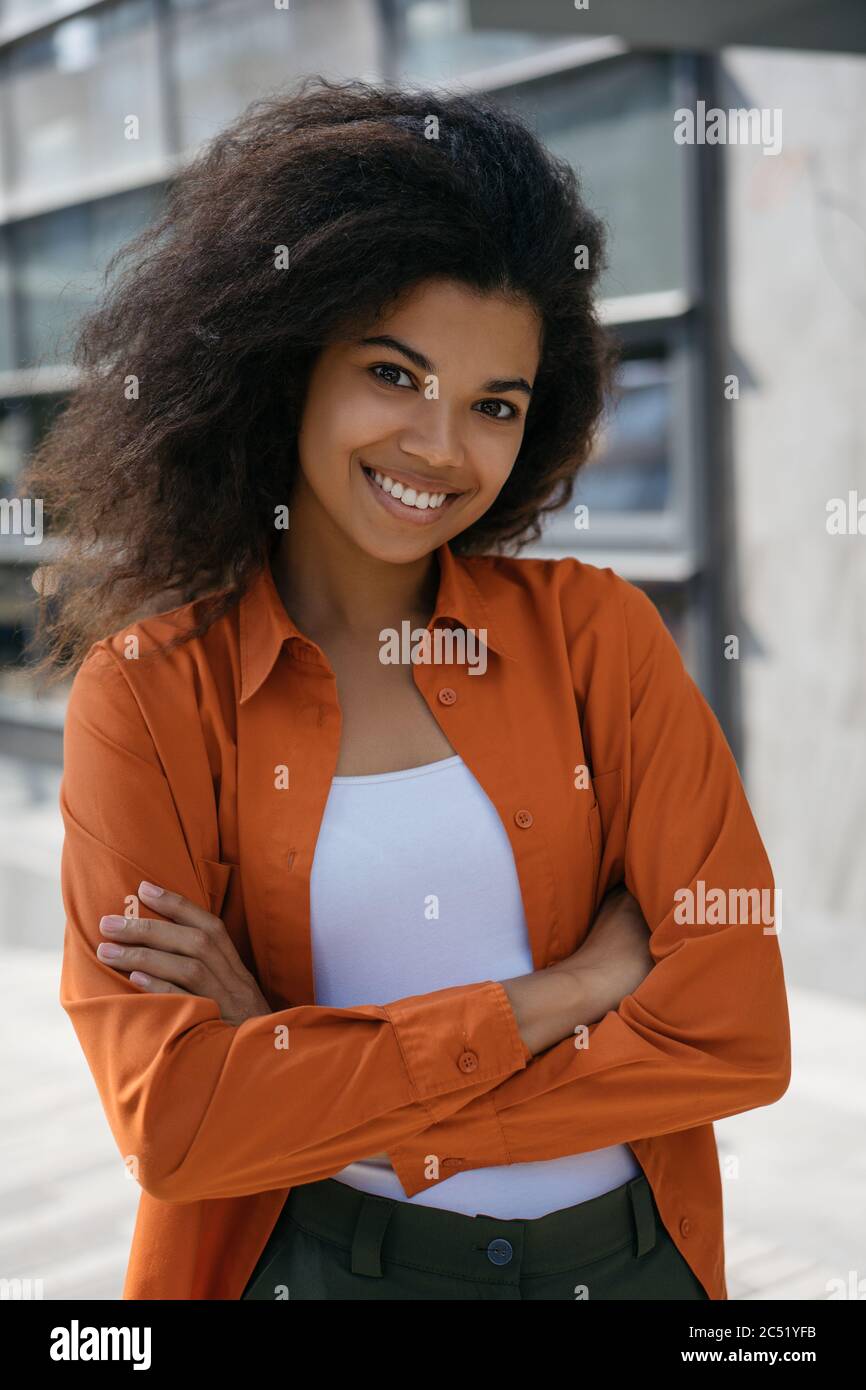 Attractive African American businesswoman with arms crossed standing ...