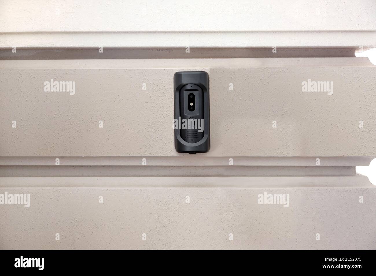 intercom with a doorbell and video link, closeup of a security device on a wall with copy space on outdoors exterior nobody. Stock Photo