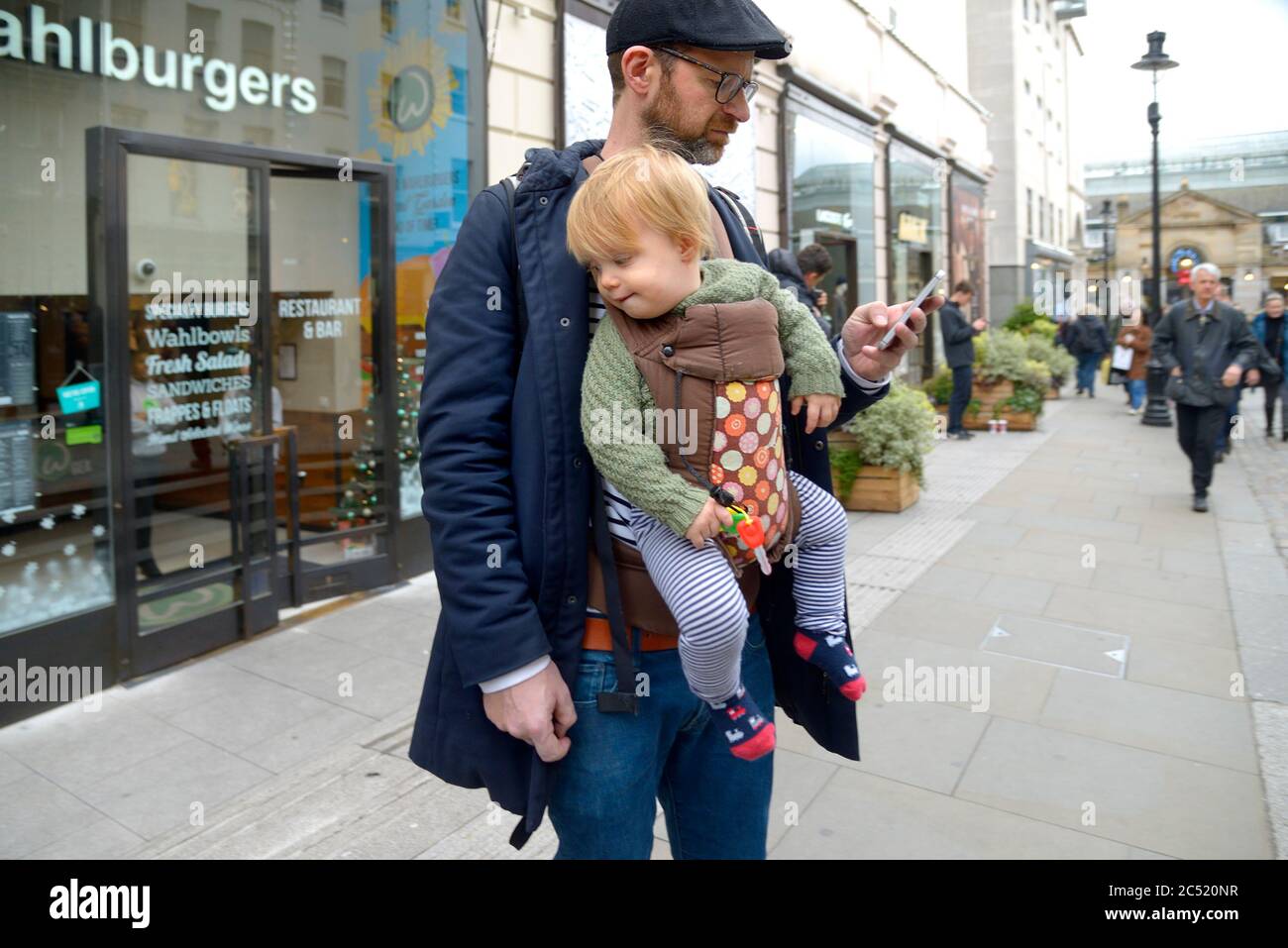London, England, UK. Father carrying his child in a papoose baby carrier Stock Photo