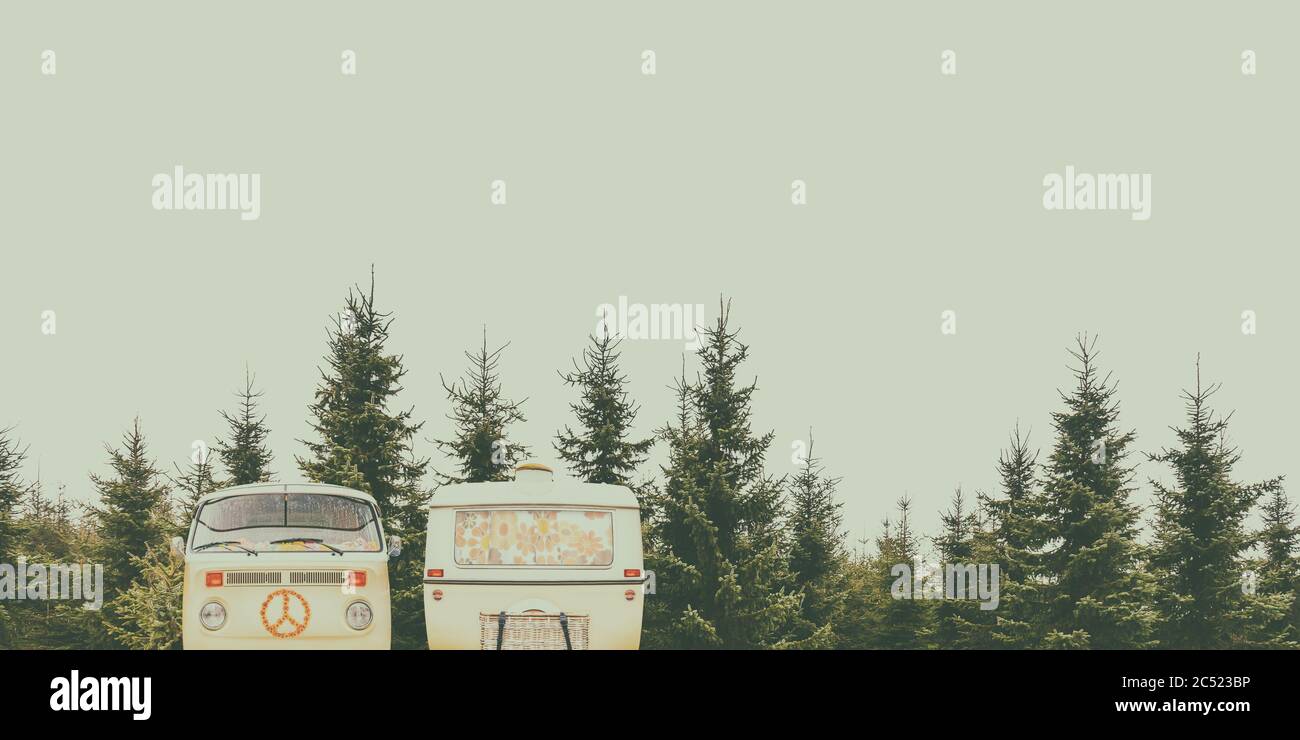 Retro styled image of a vintage camper and caravan in a forest Stock Photo