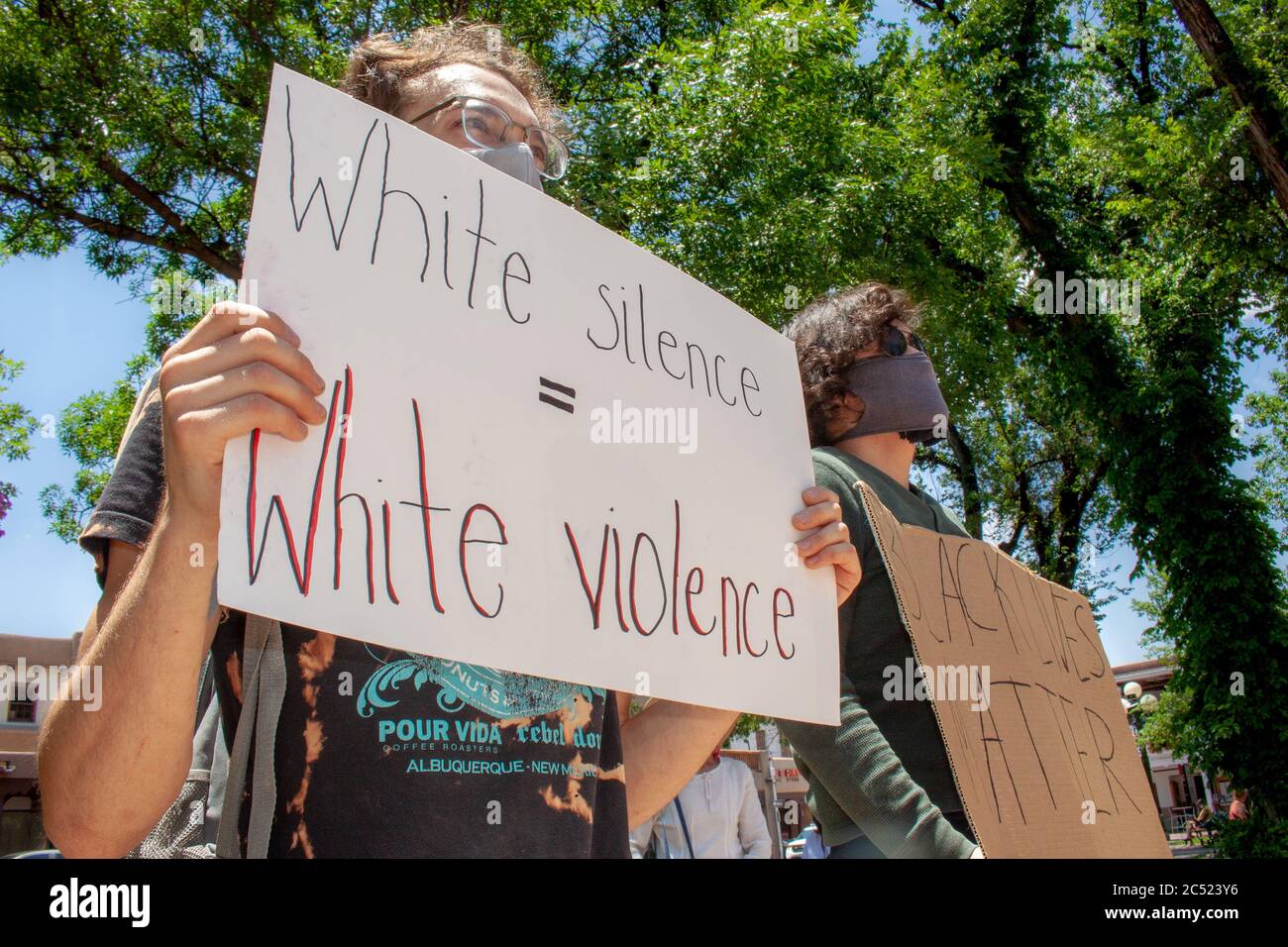 Santa Fe, New Mexico / USA - June 20 2020: young white man holds up 'white silence = white violence' sign at a Black Lives Matter protest in Santa Fe Stock Photo