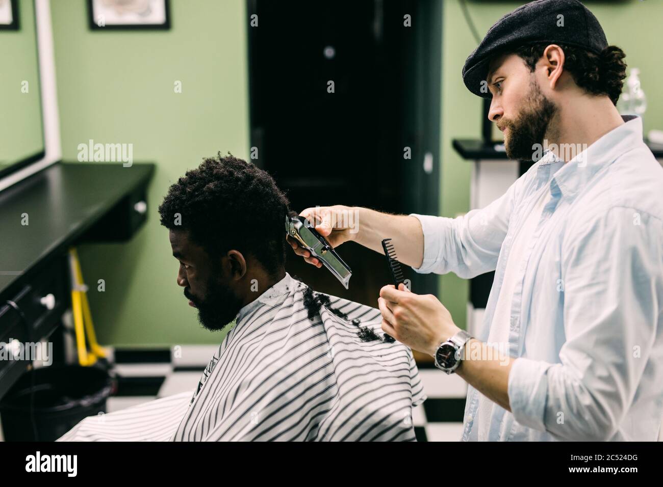 Portrait of young black man in barbershop.Handsome African guy makes new haircut in barber shop salon. Stock Photo