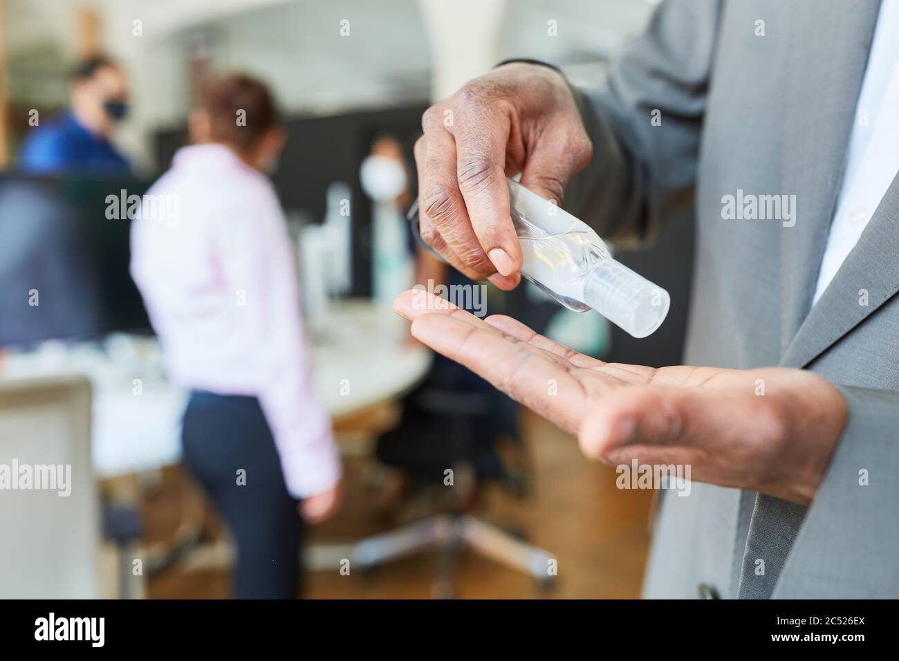 Business man disinfecting hands with disinfectant because of Covid-19 and corona virus Stock Photo