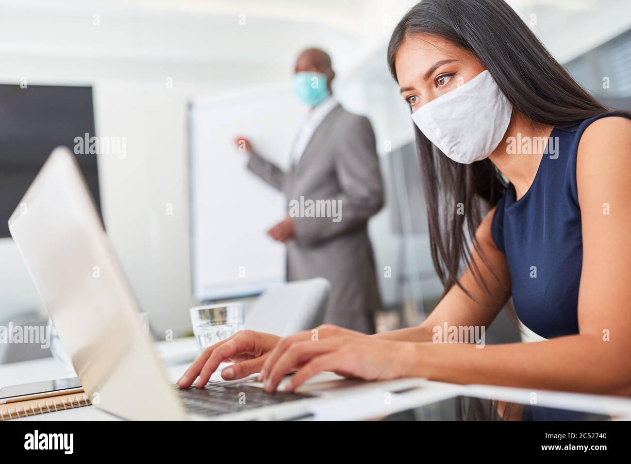 Businesswoman with face mask because of Covid-19 and corona virus works ...