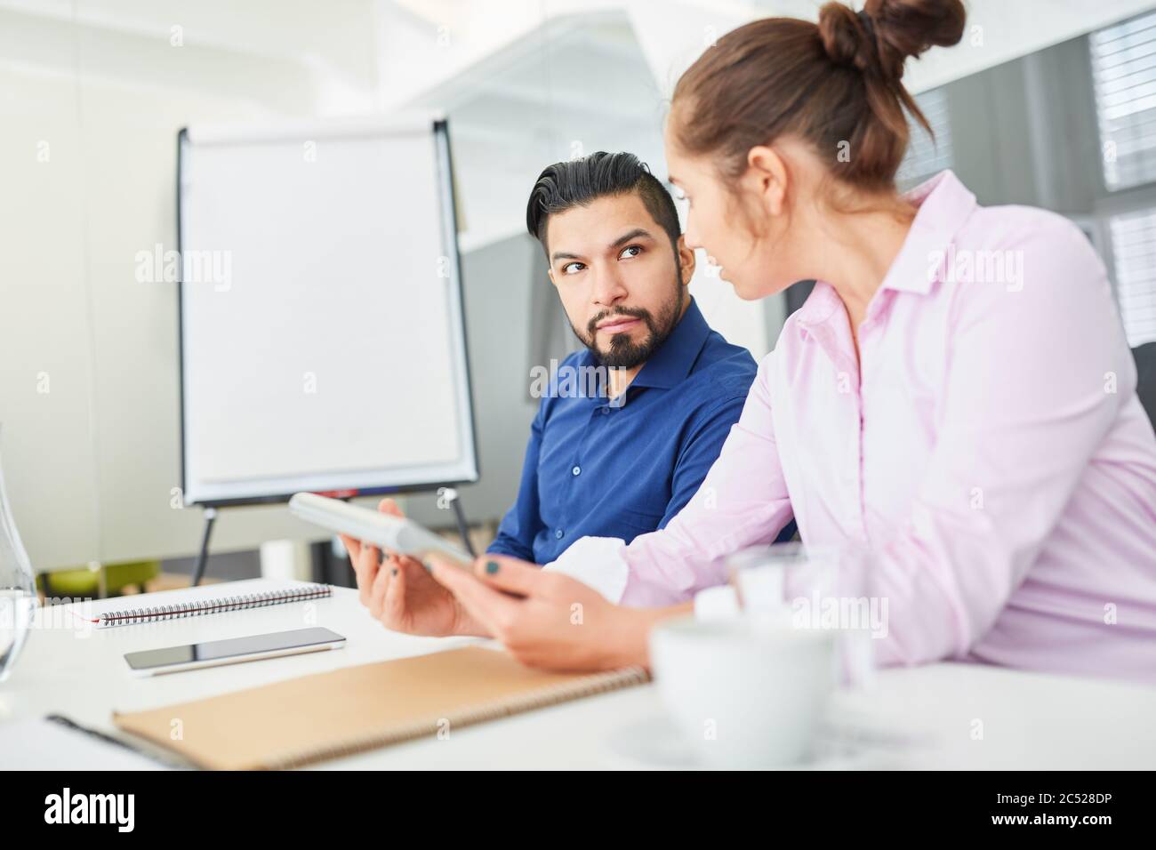 Two business people work together as a team on a project in a meeting in the office Stock Photo