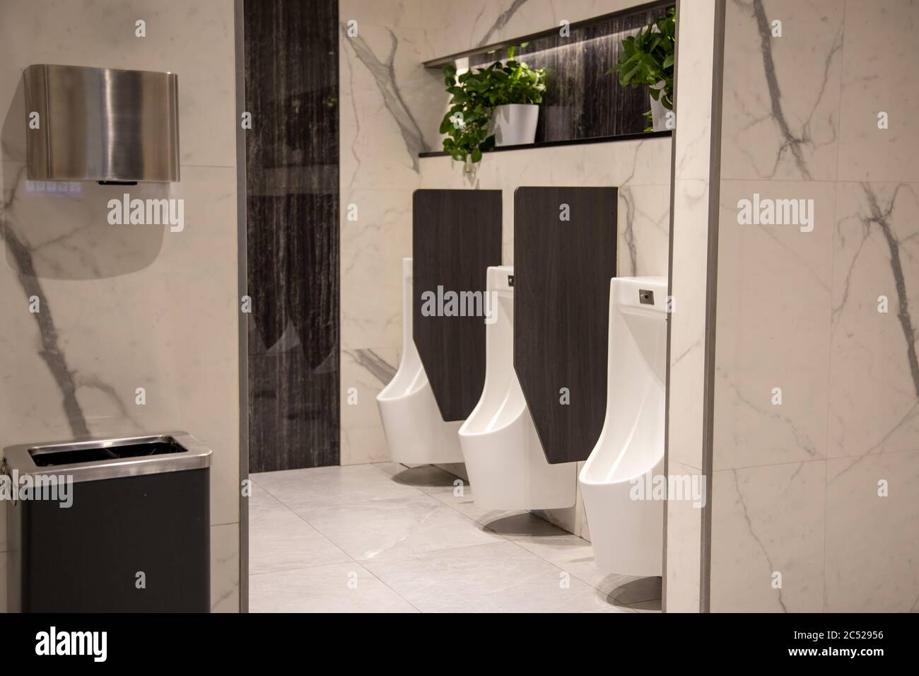 white urinals in a modern premium public restroom. men's toilet