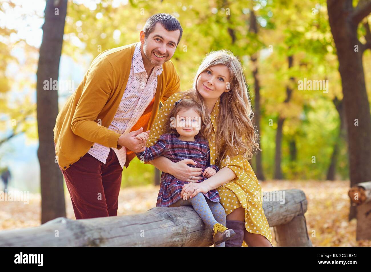 Family playing with baby in the park in autumn. Stock Photo