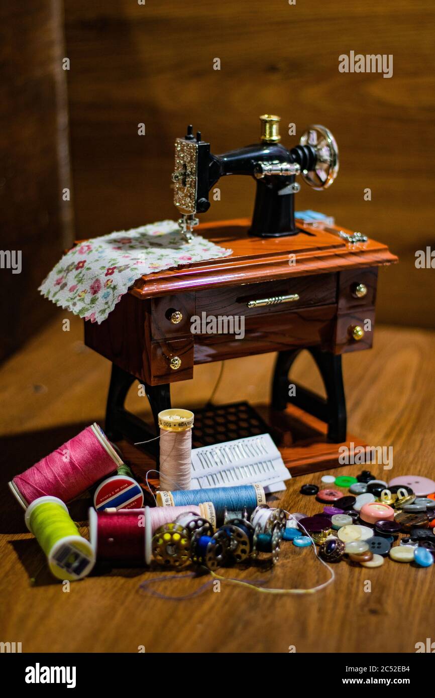 Thread Toy Machine Toy sewing machine on the wooden table and colorful threads and buttons ...