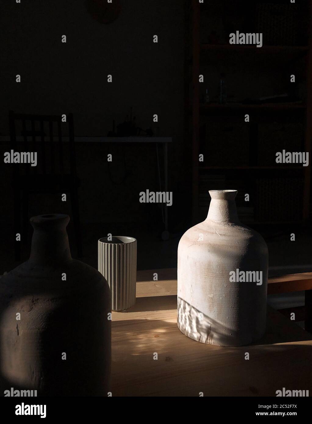 Three vases on a table in the sunlight Stock Photo