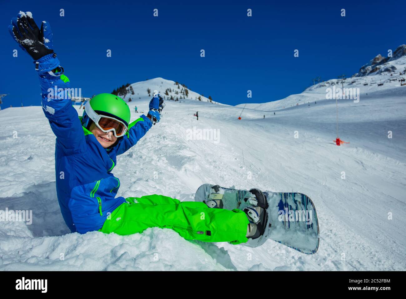Close image of a little boy with snowboard sit on the snow view from