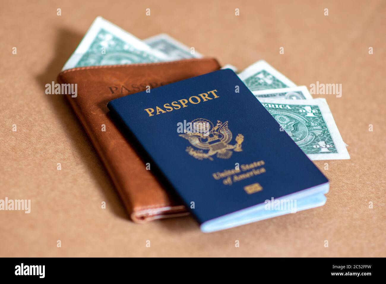 Concept photo of American tourists spending US Dollars and through travel after coronavirus. American passport, leather passport cover, and bank notes. Stock Photo