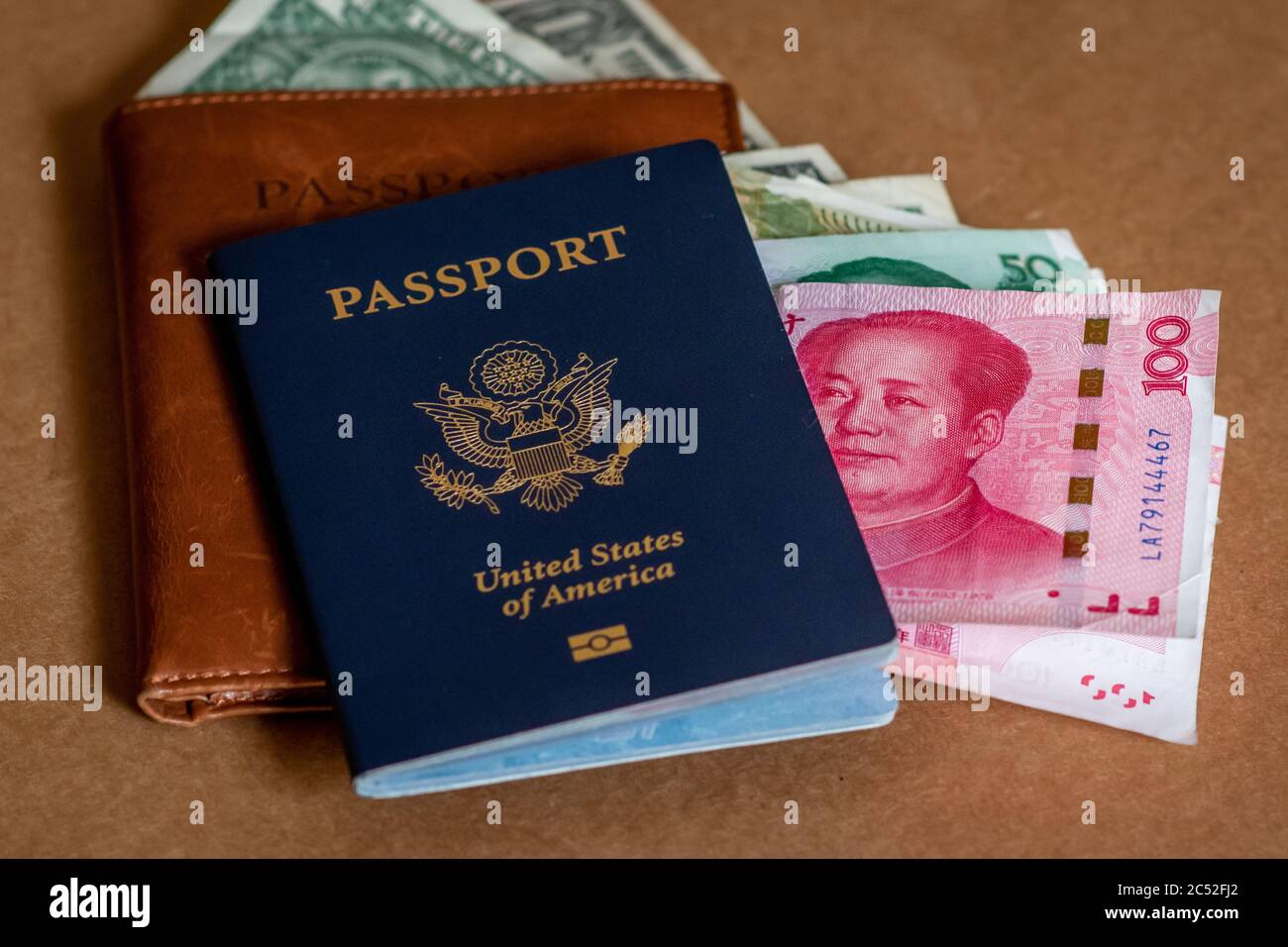 Concept photo of American tourists spending US Dollars and through travel after coronavirus. American passport, leather passport cover, and bank notes. Stock Photo