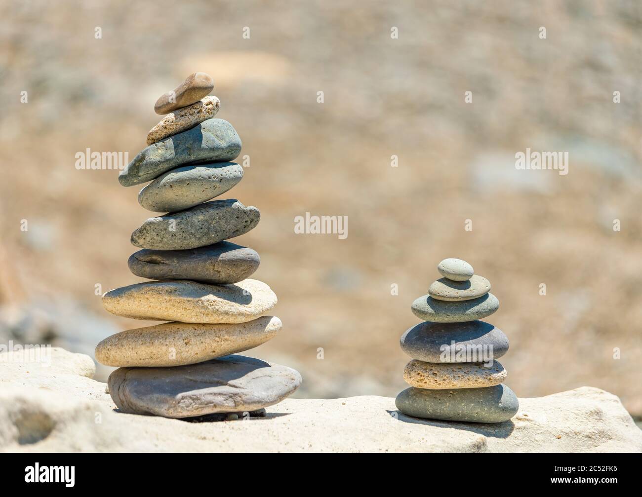 Balanced Pebbles Pyramid on the Beach on Sunny Day and Clear Sky at Sunset. Blue Sea on Background Selective focus, zen stones on sea beach Stock Photo