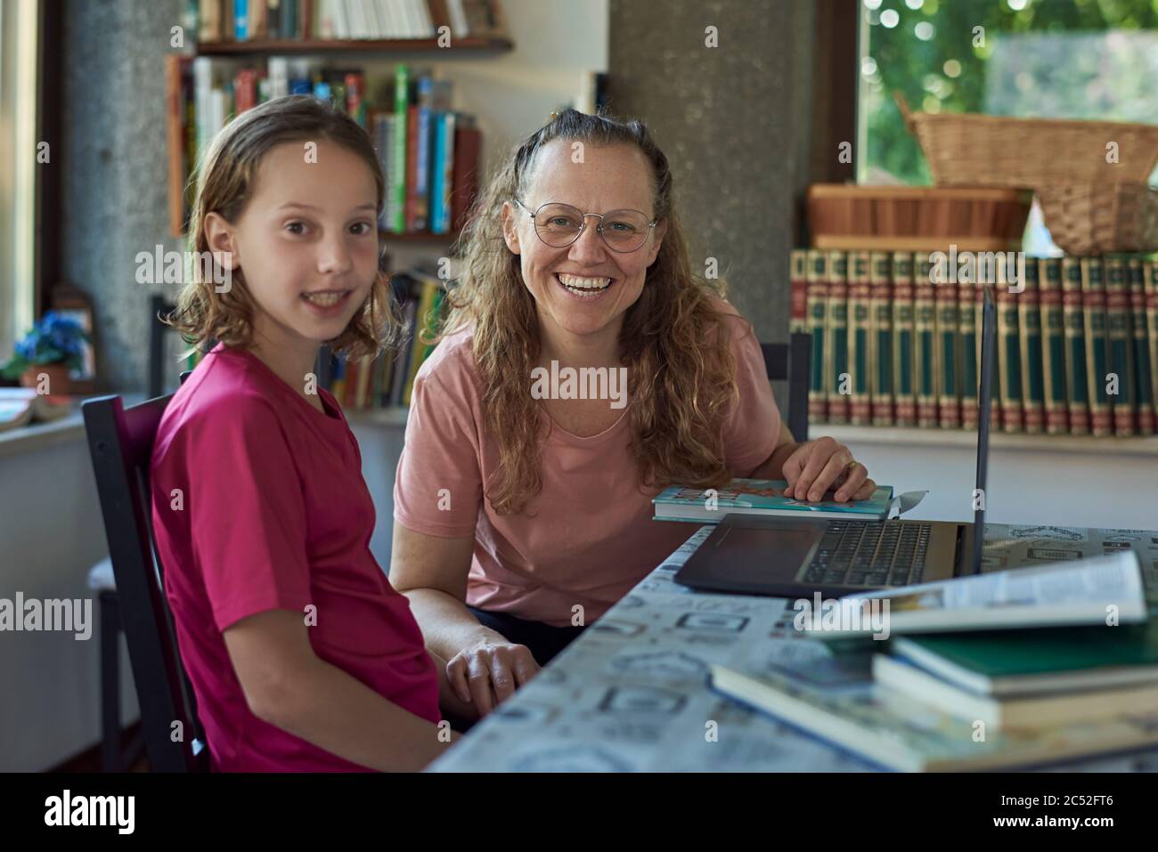 Mother and daughter infront of the laptop studying online Stock Photo