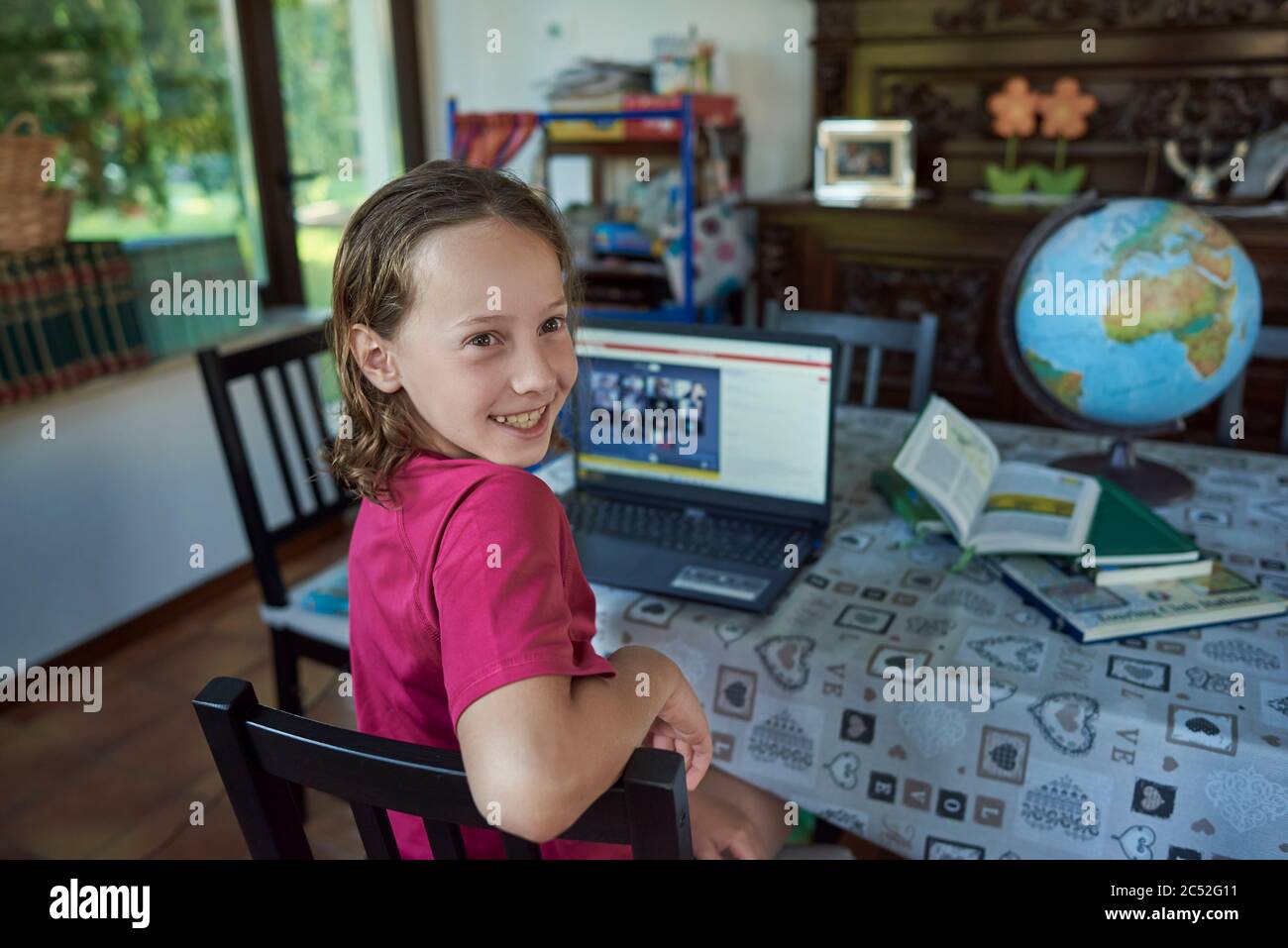 Girl smiling infront of the laptop at her home Stock Photo