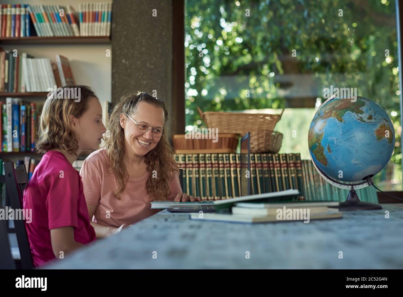 Mother and daughter infront of the laptop studying online Stock Photo