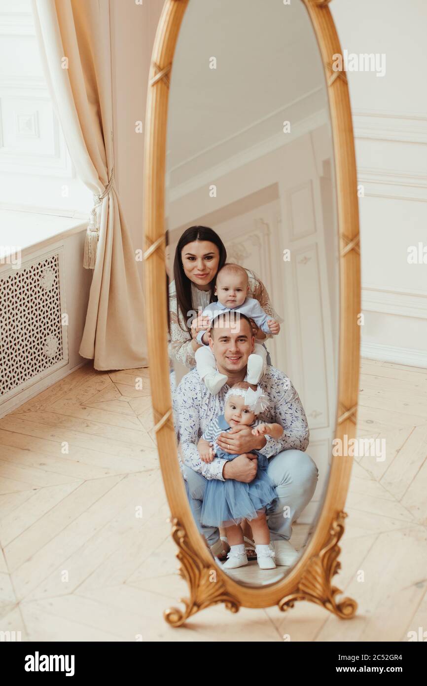 Portrait of a family standing in front of a full length mirror Stock Photo