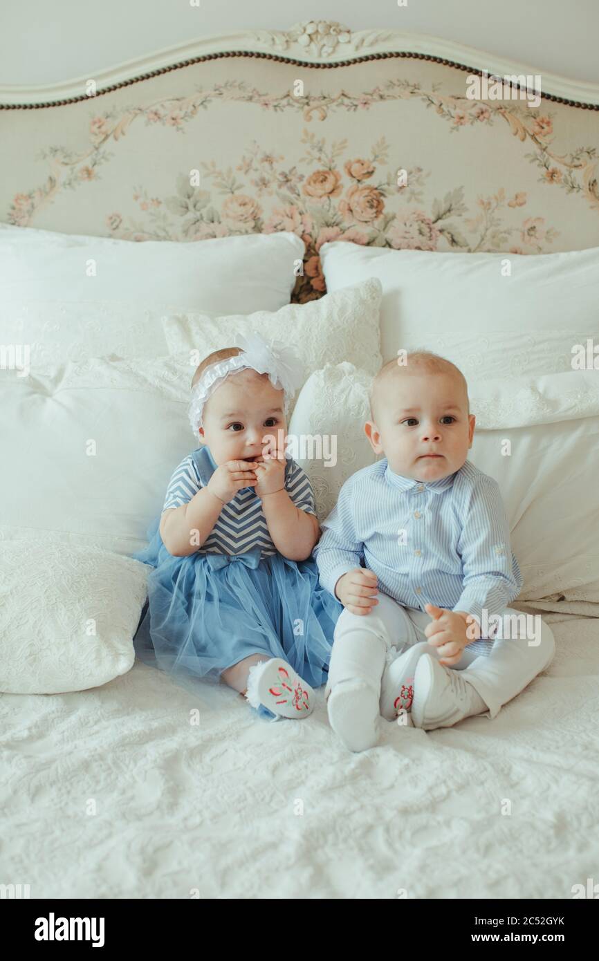 Boy and girl twins sitting on a bed Stock Photo