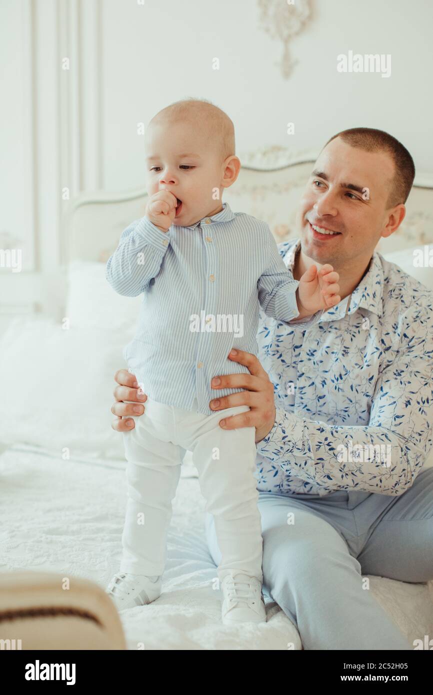 Father sitting on a bed with his baby son Stock Photo