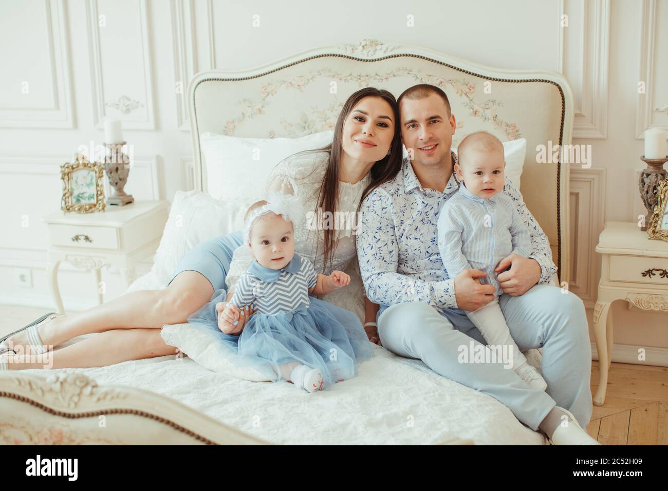 Portrait of a family sitting on a bed Stock Photo