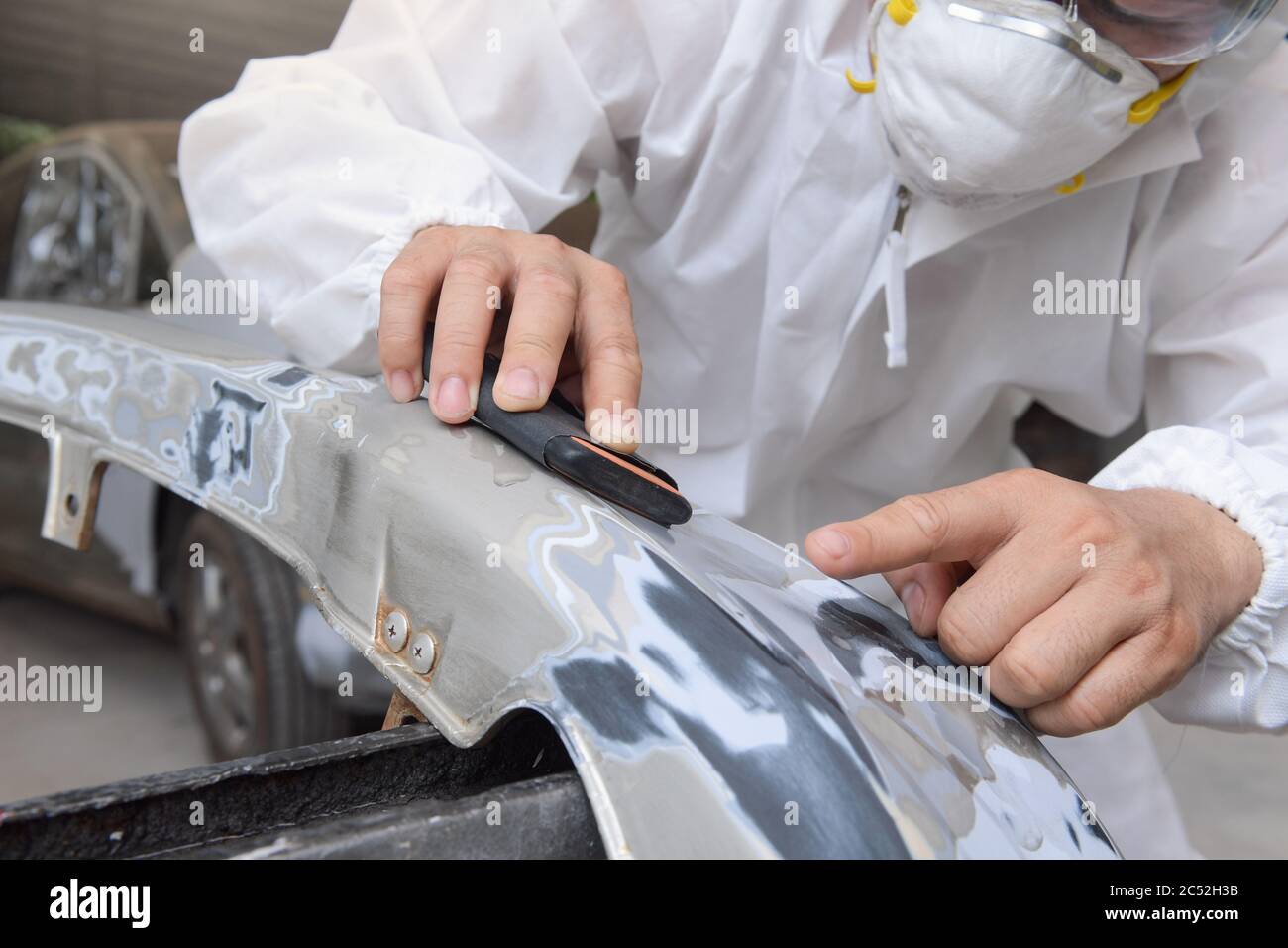 Mechanic polishing a car in a garage Stock Photo