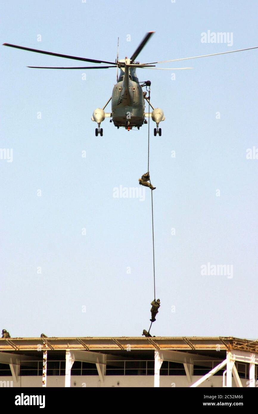 Italian Special Forces personnel FAST rope from an Italian SH-3D helicopter down to the deck of USNS PFC Eugene A. Obregon (T-AK-3006) in the Mediterranean Sea on 22 April 2004 (040422 Stock Photo