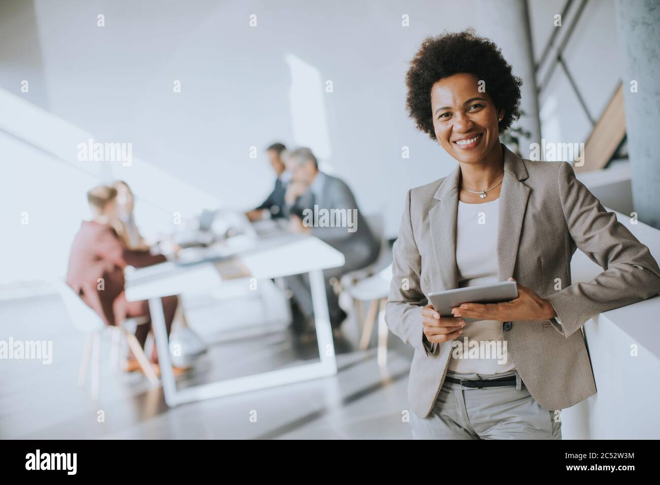 Young African American businesswoman standing using digital tablet in the modern office Stock Photo