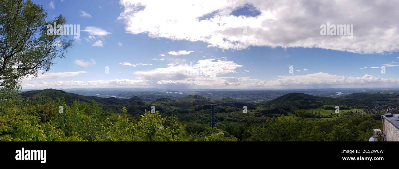 Aerial panoramic view of a green forest under blue sky and white clouds ...