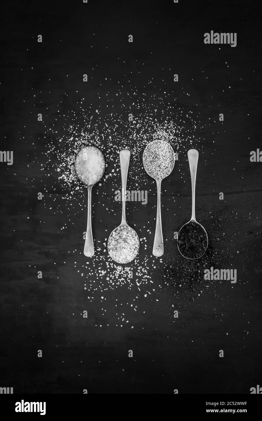 Antique silver spoons with various types of salts and spices laid out