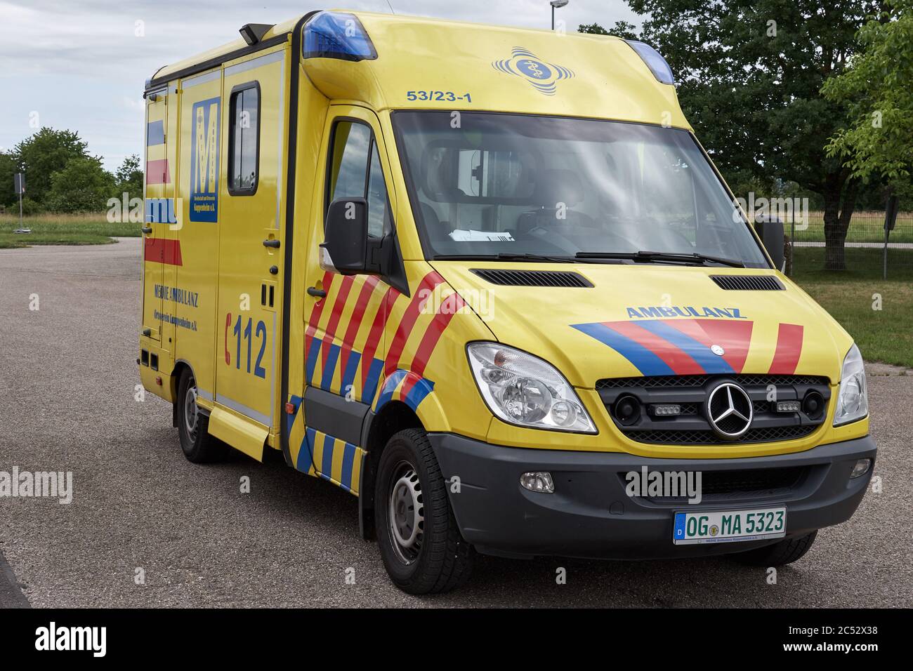 Yellow ambulance vehicle with German emergency phone number 112 Stock Photo