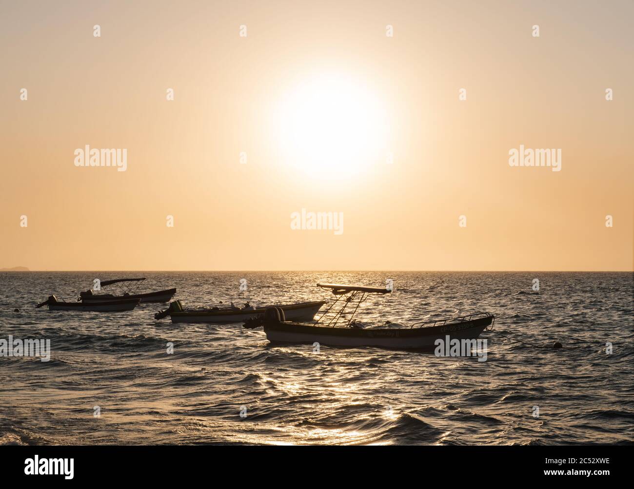 Boats in the water at Playa Blanca beach at Sunset, Cartagena, Colombia Stock Photo